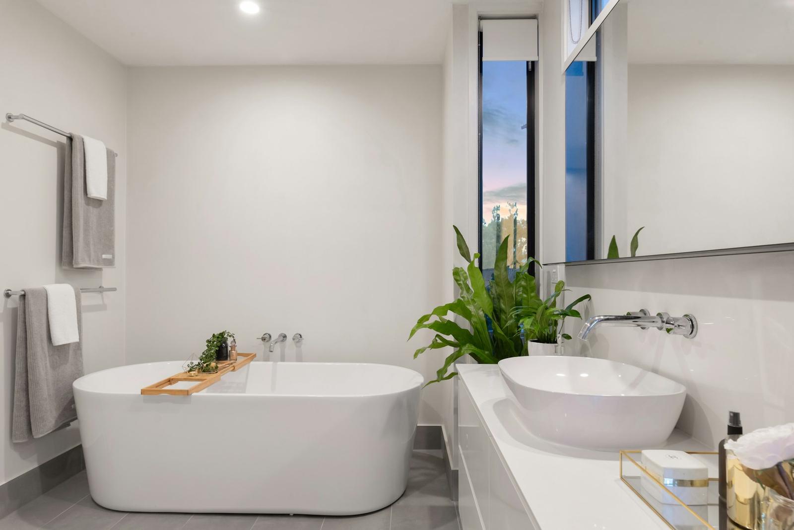 Bathroom with large grey floor tile and a freestanding tub
