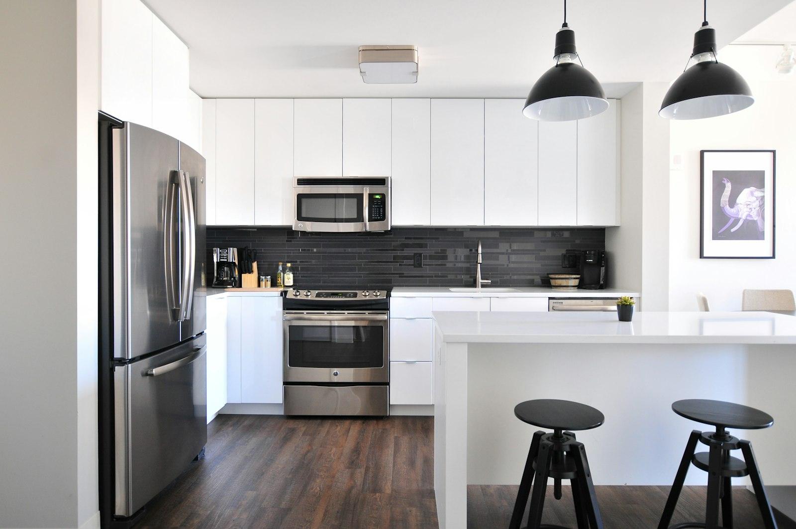 Kitchen with dark flooring and a dark tile backsplash